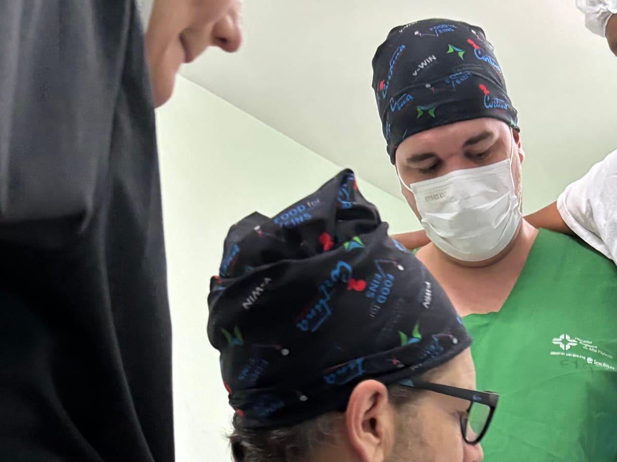 Two surgeons in printed scrub caps conferring over a case in the operating room