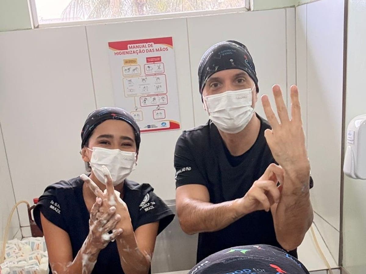 Two team members scrubbing in at the hand hygiene station before entering the OR