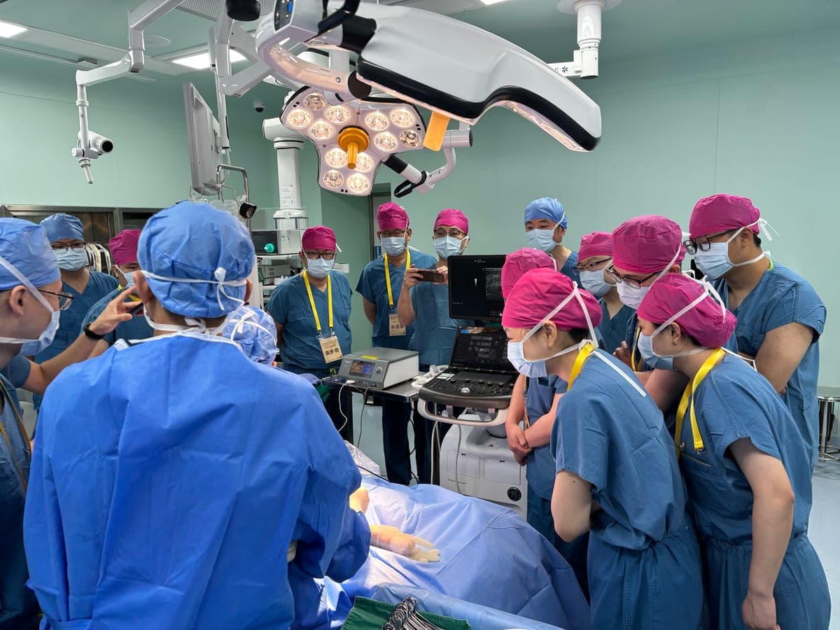 Trainees gathered around the ultrasound monitor during a live case transmission
